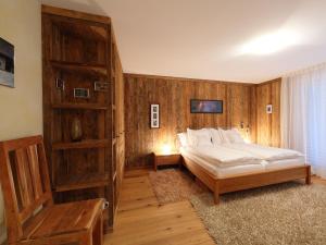 1 dormitorio con 1 cama y pared de madera en Apartment Rütschi-5 by Interhome, en Zermatt