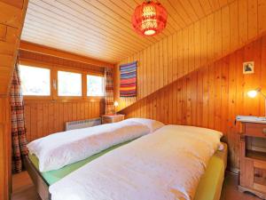 two beds in a room with wooden walls at Apartment Lauberhaus by Interhome in Zermatt