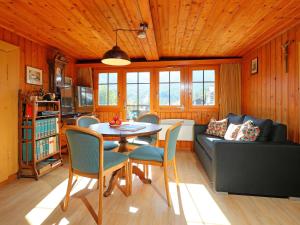 ein Wohnzimmer mit einem Tisch, Stühlen und einem Sofa in der Unterkunft Apartment Lauberhaus by Interhome in Zermatt