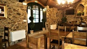un restaurante con mesa, sillas y ventana en Casa de los Somoza, en Melide