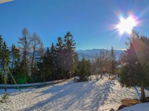 a snow covered road with the sun in the sky at Apartment Vermala-Soleil A-B-4 by Interhome in Vermala
