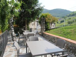 patio ze stołami i krzesłami oraz kamienną ścianą w obiekcie Apartment La Tartufaia-6 by Interhome w Tremosine Sul Garda +19 zdjęć