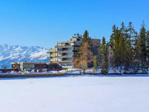 a building in the snow next to a snow covered field at Apartment Jeanne D'Arc Apt- H2-49 by Interhome in Crans-Montana