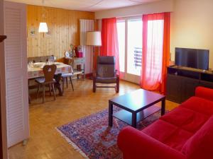 sala de estar con sofá rojo y mesa en Apartment Armorial by Interhome, en Vermala