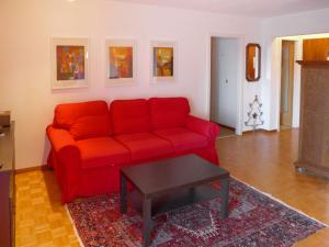 un sofá rojo en una sala de estar con mesa en Apartment Armorial by Interhome, en Vermala