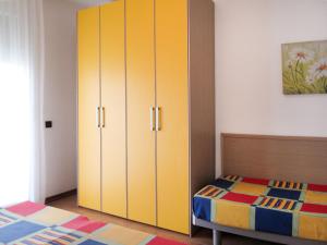 1 dormitorio con armario amarillo junto a la cama en Holiday Home La Quercia-Le Farnie - CAO422 by Interhome en La Fagiana