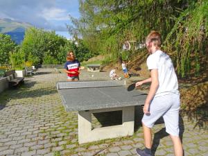 Un groupe de jeunes garçons jouant au ping-pong dans l'établissement Apartment Aragon B48 by Interhome, à Ernen