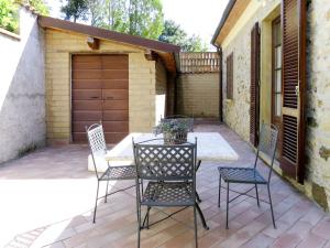 patio con sillas, mesa y garaje en Apartment Magnolia by Interhome, en Santa Luce