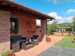 eine Terrasse eines Hauses mit 2 Stühlen und einem Tisch in der Unterkunft Holiday Home Casale L'Uliveta by Interhome in Canneto