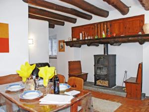 comedor con mesa y estufa de leña en Holiday Home Casa la Rustica by Interhome, en Brione