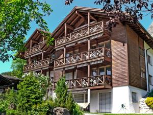 ein großes Holzhaus mit Balkon in der Unterkunft Apartment Rose Studio Y by Interhome in Wengen