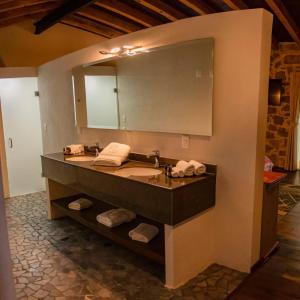 baño con lavabo y espejo grande en Hotel Casa Xaa en Tlatlauquitepec