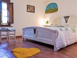 Fattoria SpedalettoにあるApartment Casanuova - Caciaia - LAI131 by Interhomeのベッドルーム(白いベッド1台、テーブル付)