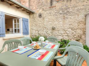 a green table and chairs on a patio at Holiday Home Doumer by Interhome in Royan