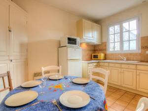 a kitchen with a table with plates and glasses on it at Holiday Home Doumer by Interhome in Royan