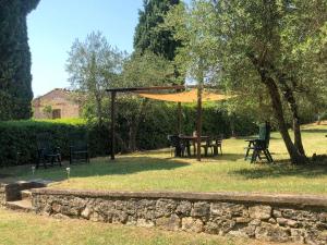 a table and chairs under a canopy in a yard at Apartment Loggetta by Interhome in Podere Caminino