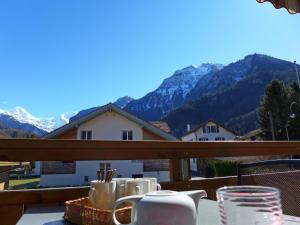 - une table avec des tasses et des tasses sur un balcon avec des montagnes dans l'établissement Apartment Oberei by Interhome, à Wilderswil