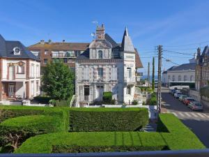 een groot wit gebouw met een toren op een straat bij Apartment Le Manoir du Casino by Interhome in Cabourg