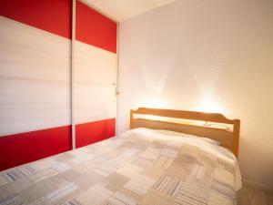 - une chambre dotée d'un lit avec un mur rouge et blanc dans l'établissement Apartment Les Sables d'Or-5 by Interhome, au Grau-du-Roi