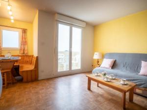 ein Wohnzimmer mit einem blauen Sofa und einem Tisch in der Unterkunft Apartment Les Sables d'Or-5 by Interhome in Le Grau-du-Roi