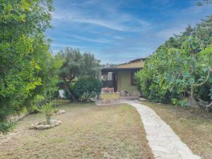 una casa con un cortile alberato e un vialetto di Holiday Home Valle degli Oleandri - REI185 by Interhome a Monte Nai
