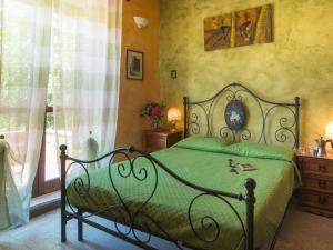 een slaapkamer met een groen bed en een raam bij Apartment Casa Domenico n- 1 by Interhome in Montefiascone