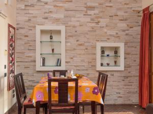 una sala da pranzo con tavolo, sedie e muro di mattoni di Apartment Appartamento Doria - REI186 by Interhome a Monte Nai