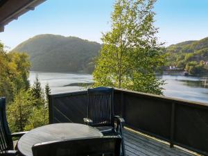 a table and chairs on a deck with a view of a river at Holiday Home Haugen by Interhome in Lyngdal +17 photos