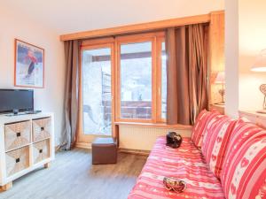 een woonkamer met een bank en een groot raam bij Apartment Le Curling A-2 by Interhome in Tignes