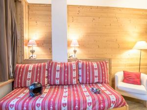 een slaapkamer met een bed met rode en witte lakens bij Apartment Le Curling A-2 by Interhome in Tignes