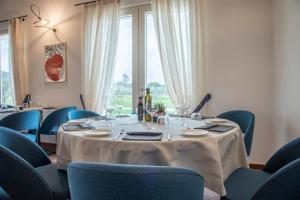 una sala da pranzo con tavolo e sedie blu di Riva Toscana Golf Resort & SPA a Follonica