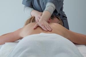 a woman getting a massage from a therapist at Riva Toscana Golf Resort & SPA in Follonica