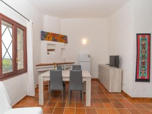 una cucina con tavolo, sedie e frigorifero di Holiday Home Ville Sant'Elmo - REI241 by Interhome a Monte Nai