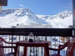 ティーニュにあるApartment Le Prariond-6 by Interhomeの雪に覆われた山のバルコニー(テーブル、椅子付)