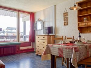Un comedor con una mesa y un gran ventanal. en Apartment Le Prariond - Val Claret-6 by Interhome, en Tignes
