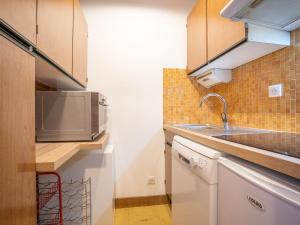 a kitchen with a sink and a microwave at Apartment Le Grand Tichot A et B - Val Claret-3 by Interhome in Tignes