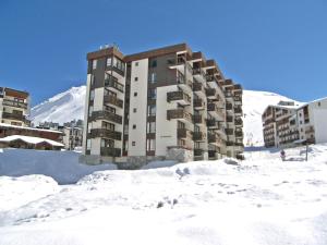 a building in the snow in front of a mountain at Apartment Le Prariond-4 in Tignes