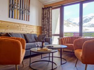 a living room with a couch and tables and chairs at Apartment Le Grand Tichot A et B - Val Claret-9 by Interhome in Tignes