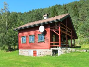 a red cabin in the middle of a field at Chalet Målsnes - FJS015 by Interhome in Balestrand