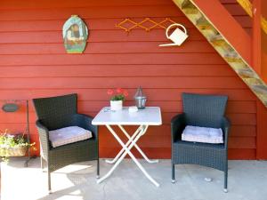 two chairs and a table in front of a red wall at Chalet Målsnes - FJS015 by Interhome in Balestrand