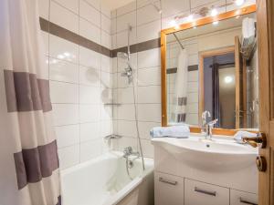 un bagno con un lavandino, una vasca e uno specchio di Studio Pegase Phenix-44 by Interhome a Le Corbier