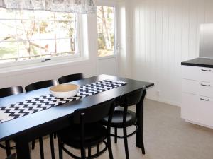 Una cocina con una mesa negra y sillas negras. en Holiday Home Solsvika by Interhome, en Leirvik