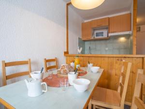 a kitchen with a table with white dishes on it at Apartment Les Grandes Platières-12 by Interhome in Tignes