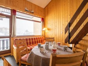 a dining room with a table and a couch at Apartment Les Asters-1 by Interhome in Les Menuires