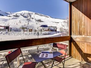 a table and chairs on a balcony with a ski slope at Apartment Apollo-2 by Interhome in Le Corbier