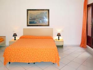 ポルトフェッラーイオにあるApartment Il Seccione-3 by Interhomeのベッドルーム1室(オレンジ色のベッドカバー付)