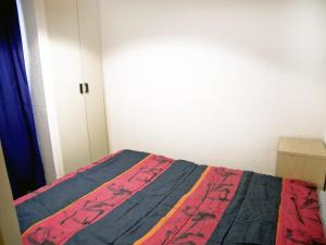 Les BoissesにあるApartment Les Olympiques - Tignes 1800-7 by Interhomeのベッドルーム1室(カラフルな毛布付きのベッド1台付)