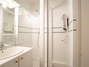 een witte badkamer met een douche en een wastafel bij Apartment L'Argousier-1 by Interhome in Les Menuires