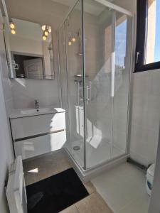 uma casa de banho branca com um chuveiro e um lavatório. em Boost Your Immo Gardette Réallon A11 em Réallon