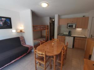 a living room and kitchen with a table and a couch at Boost Your Immo Gardette Réallon A11 in Réallon